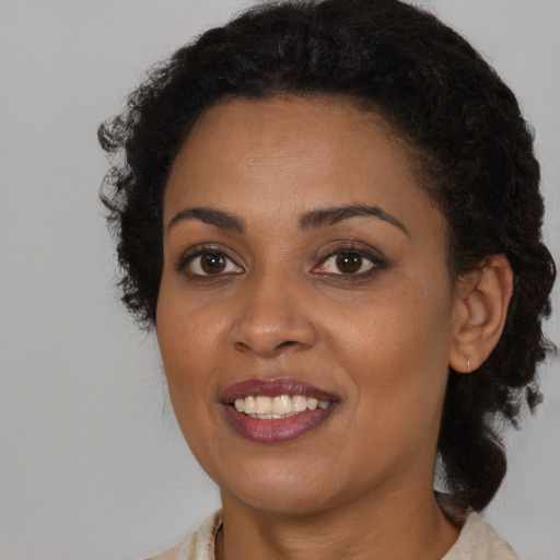 Joyful black young-adult female with medium  brown hair and brown eyes