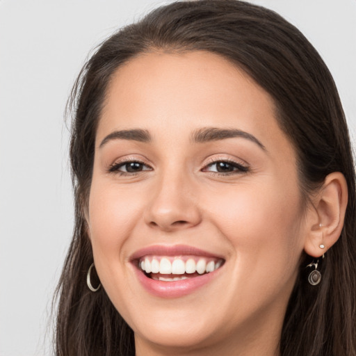 Joyful white young-adult female with long  brown hair and brown eyes