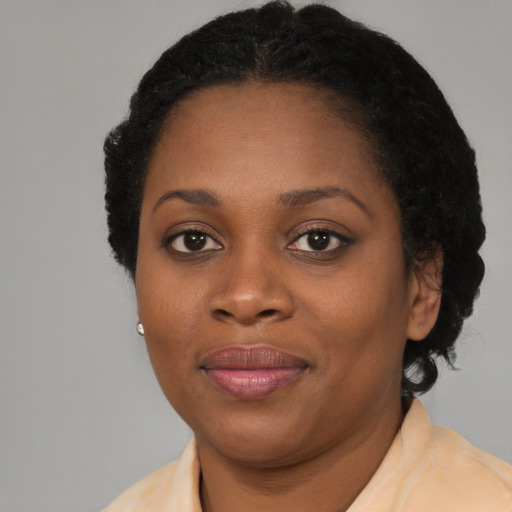 Joyful black young-adult female with short  brown hair and brown eyes