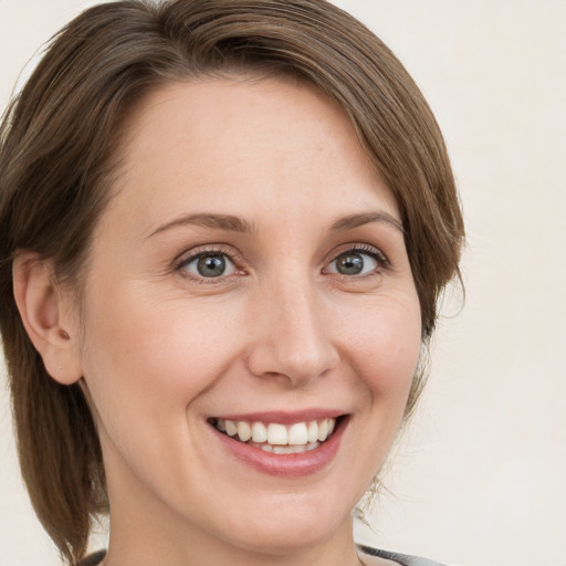 Joyful white young-adult female with medium  brown hair and grey eyes