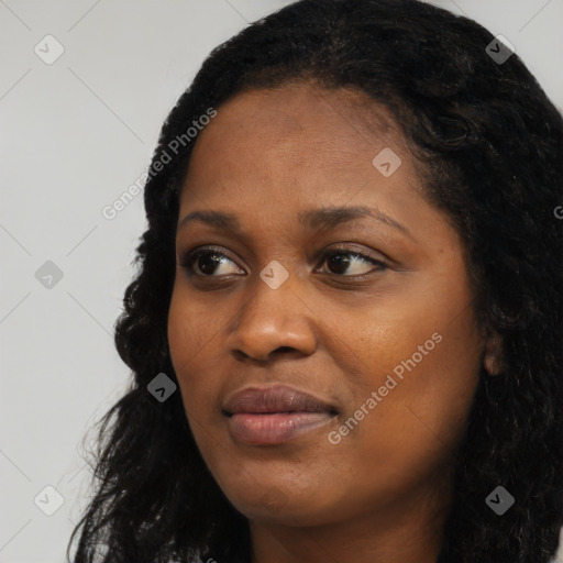 Joyful black young-adult female with long  black hair and brown eyes