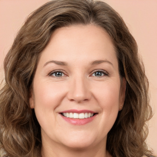 Joyful white young-adult female with long  brown hair and green eyes