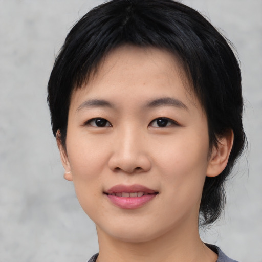 Joyful asian young-adult female with medium  black hair and brown eyes