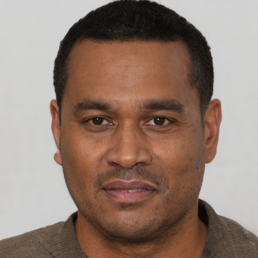 Joyful latino adult male with short  black hair and brown eyes
