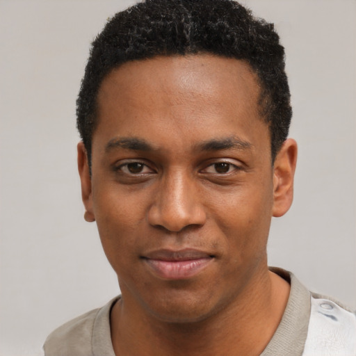 Joyful black young-adult male with short  black hair and brown eyes
