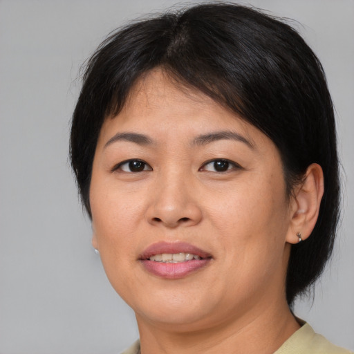 Joyful asian adult female with medium  brown hair and brown eyes