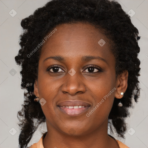 Joyful black young-adult female with long  brown hair and brown eyes