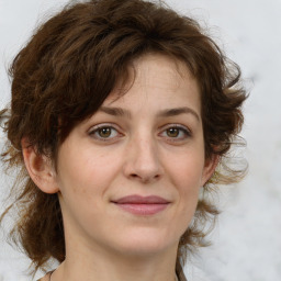 Joyful white young-adult female with medium  brown hair and green eyes