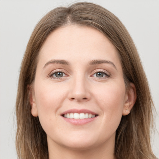 Joyful white young-adult female with long  brown hair and grey eyes