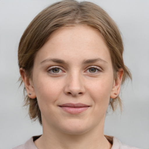 Joyful white young-adult female with medium  brown hair and grey eyes