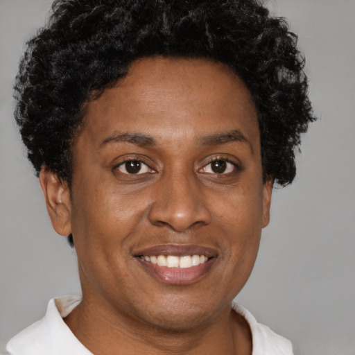 Joyful black adult female with short  brown hair and brown eyes