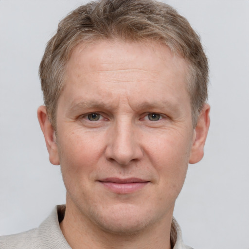 Joyful white adult male with short  brown hair and grey eyes