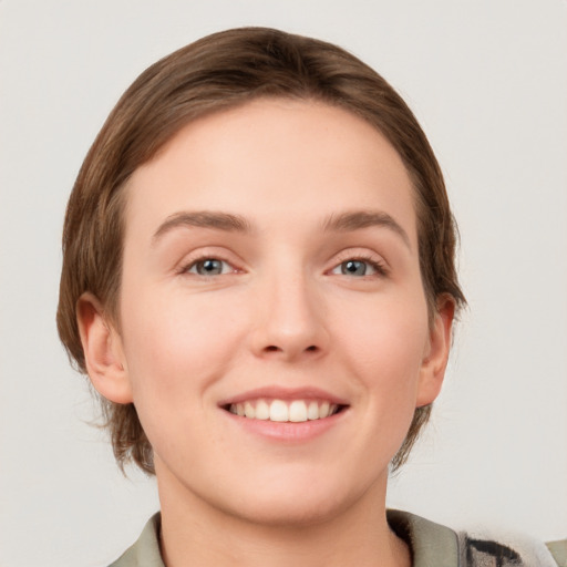 Joyful white young-adult female with medium  brown hair and grey eyes