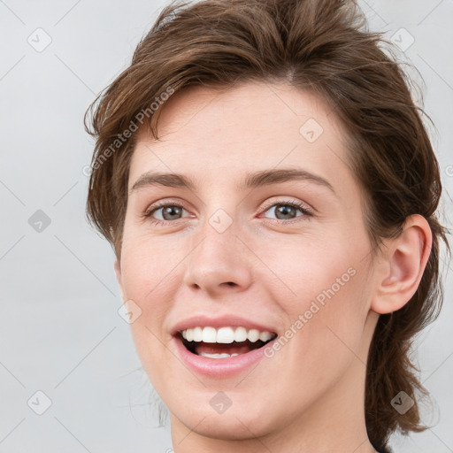 Joyful white young-adult female with medium  brown hair and grey eyes