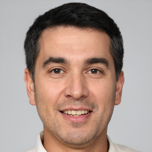 Joyful white young-adult male with short  black hair and brown eyes