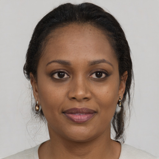 Joyful black young-adult female with medium  brown hair and brown eyes