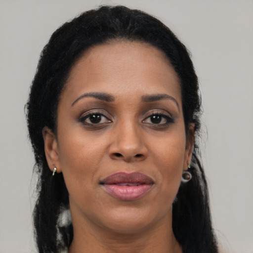 Joyful black adult female with long  black hair and brown eyes