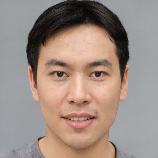 Joyful asian young-adult male with short  brown hair and brown eyes