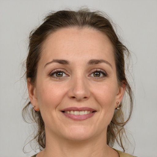 Joyful white adult female with medium  brown hair and grey eyes