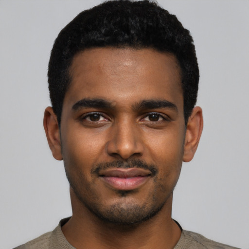 Joyful black young-adult male with short  black hair and brown eyes