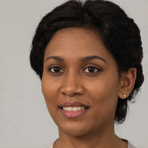 Joyful black young-adult female with medium  brown hair and brown eyes