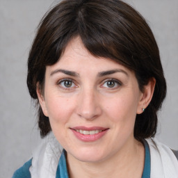 Joyful white young-adult female with medium  brown hair and blue eyes