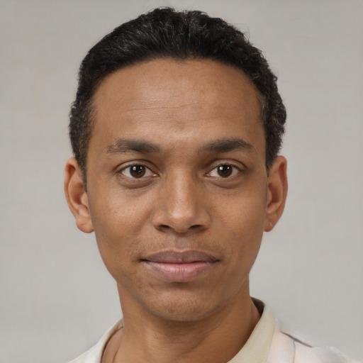 Joyful black young-adult male with short  black hair and brown eyes