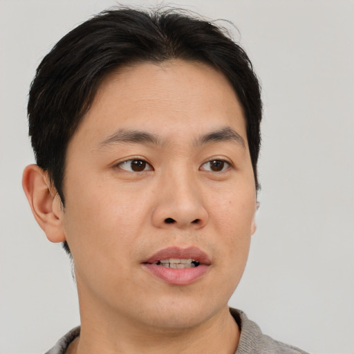 Joyful asian adult male with short  black hair and brown eyes