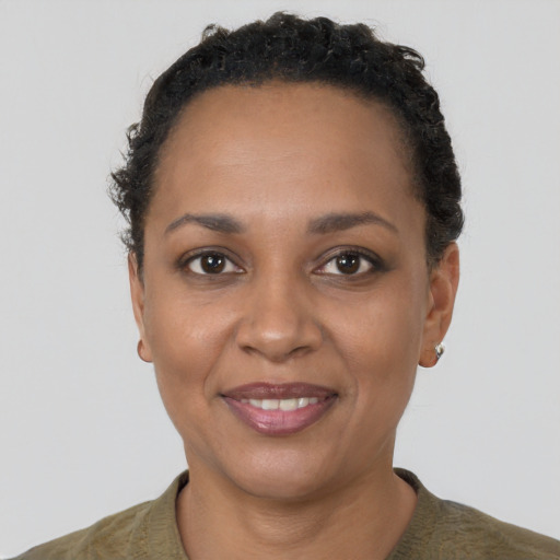 Joyful black young-adult female with short  black hair and brown eyes