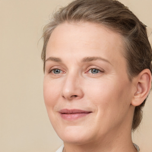 Joyful white adult female with medium  brown hair and blue eyes