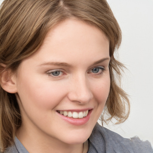 Joyful white young-adult female with medium  brown hair and blue eyes