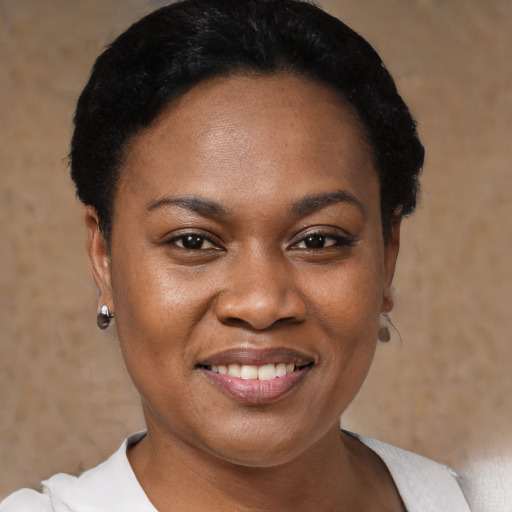 Joyful black adult female with short  black hair and brown eyes