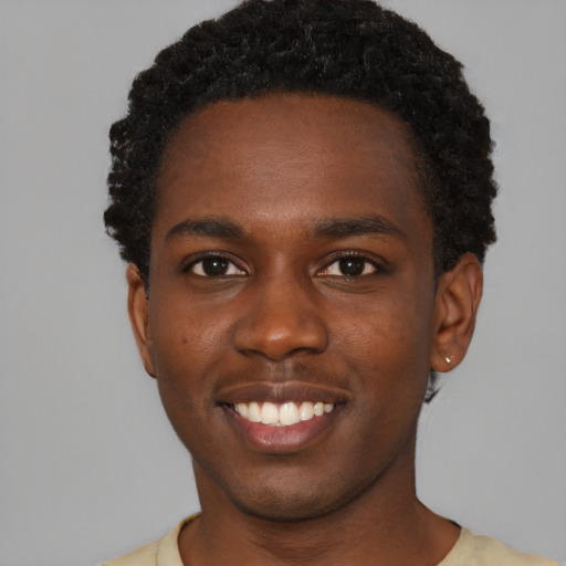 Joyful black young-adult male with short  black hair and brown eyes