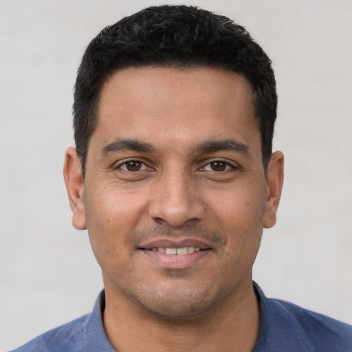 Joyful latino young-adult male with short  black hair and brown eyes