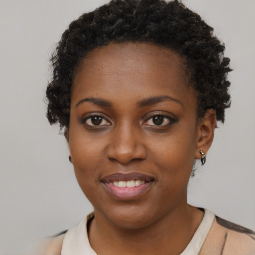 Joyful black young-adult female with short  brown hair and brown eyes