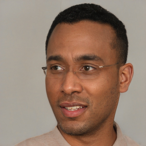 Joyful black young-adult male with short  black hair and brown eyes