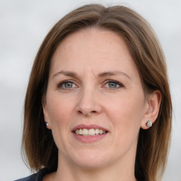 Joyful white adult female with medium  brown hair and grey eyes