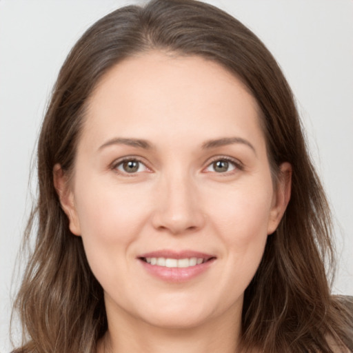 Joyful white young-adult female with long  brown hair and brown eyes