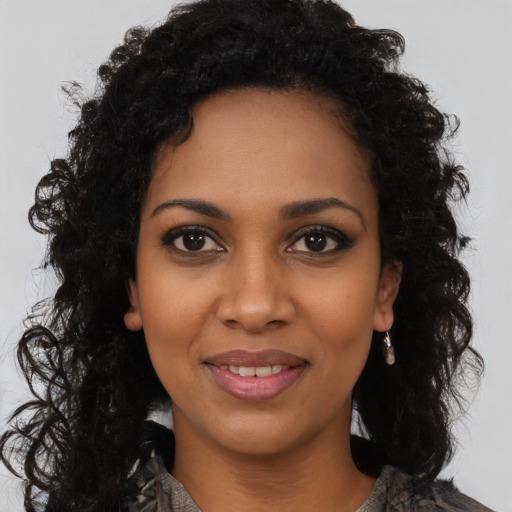 Joyful black young-adult female with long  brown hair and brown eyes