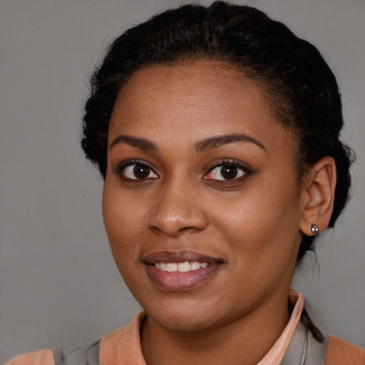 Joyful black young-adult female with short  brown hair and brown eyes