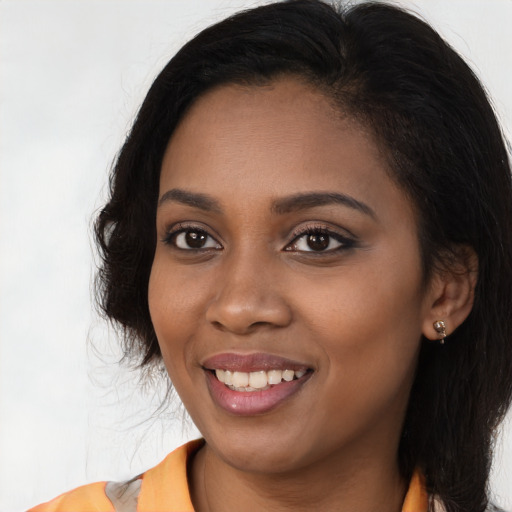 Joyful black young-adult female with long  brown hair and brown eyes