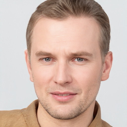 Joyful white young-adult male with short  brown hair and grey eyes