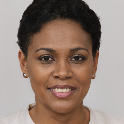 Joyful black young-adult female with short  black hair and brown eyes
