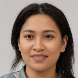 Joyful latino adult female with medium  brown hair and brown eyes