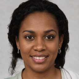 Joyful black young-adult female with medium  brown hair and brown eyes