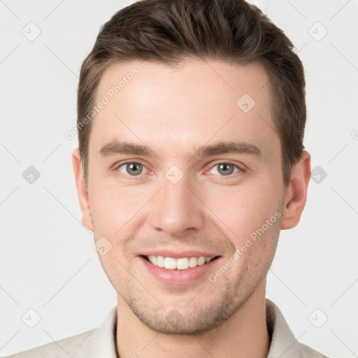 Joyful white young-adult male with short  brown hair and grey eyes