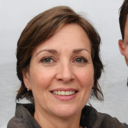 Joyful white adult female with medium  brown hair and grey eyes