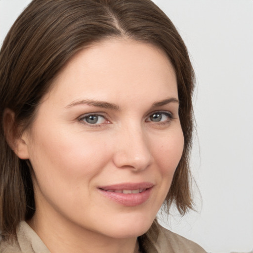 Joyful white young-adult female with medium  brown hair and grey eyes