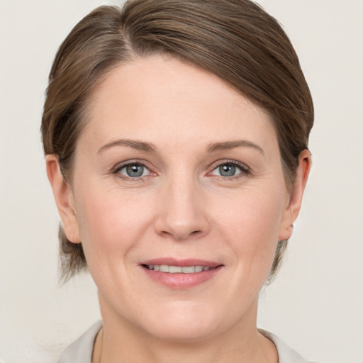 Joyful white young-adult female with medium  brown hair and grey eyes