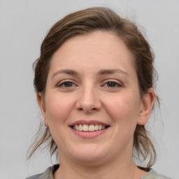 Joyful white young-adult female with medium  brown hair and grey eyes